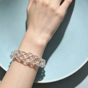 Bracciale incrociato intrecciato argentato con perle di cristallo trasparente accessorio.