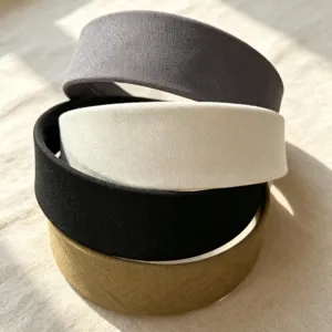 Detailed close-up of stacked wide fabric headbands in assorted classic colors for daily wear.