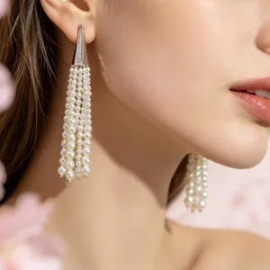 Long multi-strand pearl tassel earrings with metallic triangular top detail for elegant style.