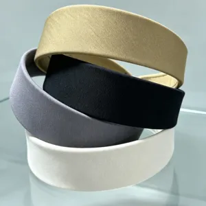 Close-up detail shot of stacked multi-color wide fabric headbands for daily wear and styling.