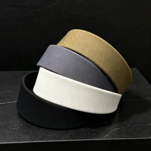 Detailed close-up of four solid color fabric wide headbands stacked neatly, showing texture.