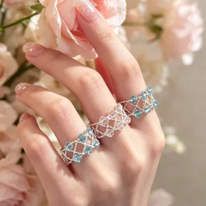 Elegantes Kristall-Perlenring-Set mit filigranem Gitterdesign und glänzenden blauen Steinen.