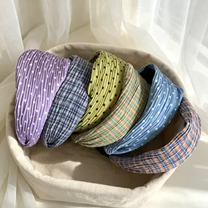 Close-up detail of Korean style pleated polka dot and plaid wide headbands in a cozy storage basket.