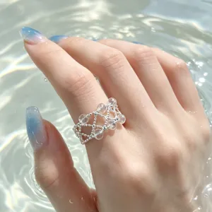 Exquisites Kristall Perlen Netto Ring Detail, glitzernder Wasser Hintergrund, eleganter Schmuck.