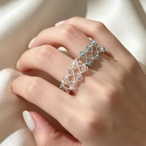 Detailaufnahme eines handgemachten Kristallperlenrings mit funkelnden Steinen am Band.