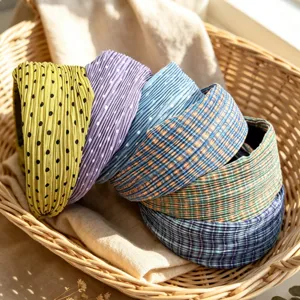 Detailed view of Korean style pleated polka dot and plaid wide hair hoops in basket storage.