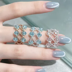Elegantes Perlenkristall-Ring-Set mit filigranen Metallgeflechtbändern und funkelnden runden Steinen.