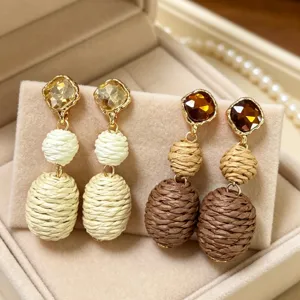 Detailed view of handmade woven thread drop earrings featuring sparkling crystal rhinestones.
