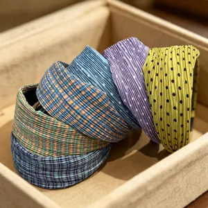Close-up detail of Korean pleated plaid and polka dot wide hair hoops in assorted bright colors.