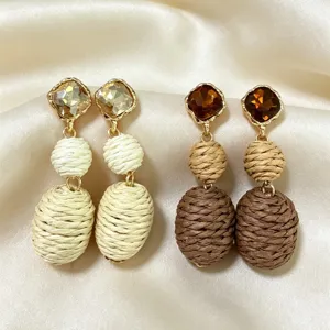 Elegant dangle earrings featuring sparkling crystal studs and woven straw beads for a chic look.