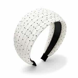 Serre-tête large blanc élégant avec des pois noirs et un design plissé pour les femmes.