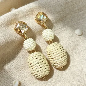 Boho retro drop earrings detail featuring sparkling crystal studs and hand-woven raffia balls.