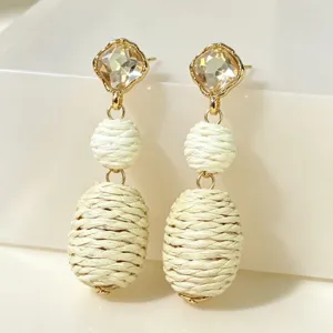 Elegant drop earrings featuring sparkling crystals and woven straw beads for a unique retro style.