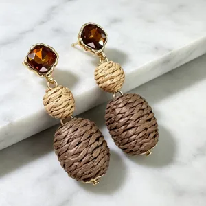 Vintage bohemian style drop earrings close up showing amber crystals and woven beads.