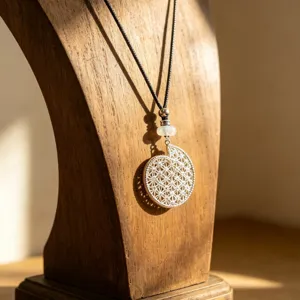 Detailed view of the silver hollow geometric pendant necklace on a wooden display stand.