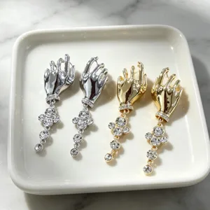 Detailed close-up shot of vintage artistic hand-shaped earrings featuring sparkling rhinestones.