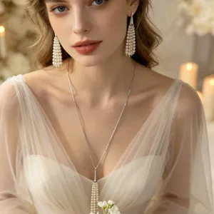 Close-up detail shot of elegant pearl tassel pendant necklace and long earrings under warm light.