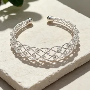 Primo piano dettaglio del bracciale aperto intrecciato argentato con perline di cristallo