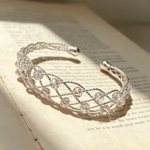 Bracciale cuff in cristallo intrecciato argento, delicato gioiello con perle per look eleganti.