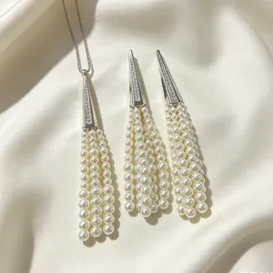 Detailed view of elegant pearl tassel necklace and earrings set with crystal cone top.