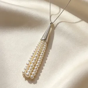 Detail view of an elegant pearl tassel pendant necklace with silver chain for women.