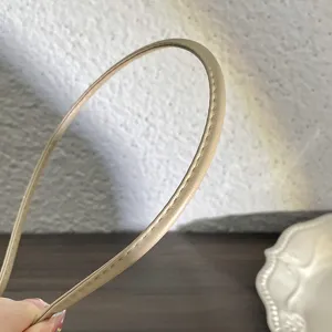 Vue rapprochée du serre-tête fin minimaliste en cuir PU beige avec une texture de couture soignée.