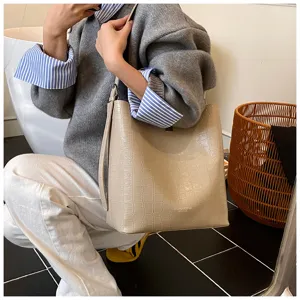 Élégant sac cabas seau en cuir motif crocodile beige, sac à épaule tendance pour femme.
