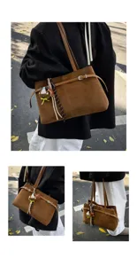 Chic brown suede shoulder bag for women, stylish tote bag with charm and strap details.