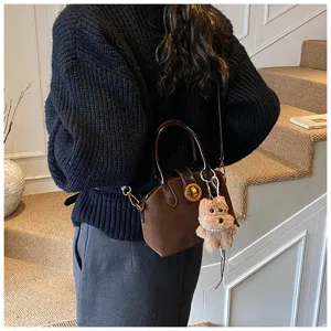 Retro brown suede shoulder bag detail, stylish women's cross-body bag with cute puppy charm.