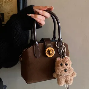 Vintage brown suede handbag for women, elegant top handle bag with cute plush bear charm.
