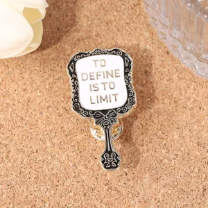 Gedetailleerd close-up van vintage spiegel metalen broche met inspirerend Engels citaatontwerp.