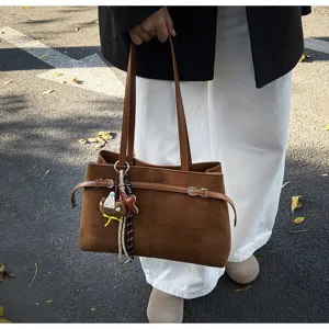 Brown suede shoulder bag for women, stylish winter tote bag with chic buckle and charms.