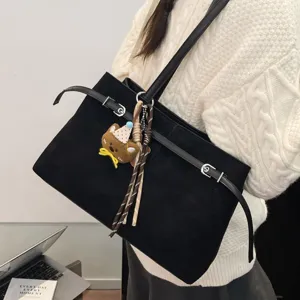 Chic black suede shoulder tote bag for women, stylish commuting underarm bag with charms.