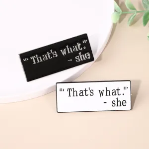 Close-up detail of stylish black and white metal enamel lapel pins with cool quote text.