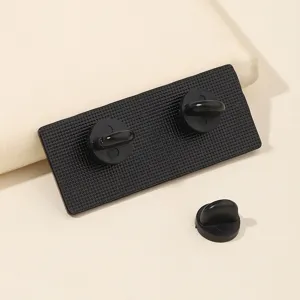 Detailed view of the metal badge back featuring secure black rubber clutch backing pins.