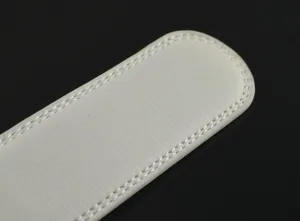 Détail de ceinture en cuir blanc avec double couture soignée et texture élégante.