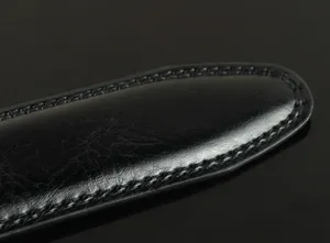 Black leather belt detail shot showcasing fine stitching craftsmanship and premium texture.