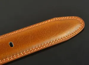 Close-up of premium men's leather belt detail, showing fine stitching and cowhide texture.