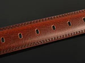 Close-up view of brown mens leather belt showing fine stitching and classic oval holes.