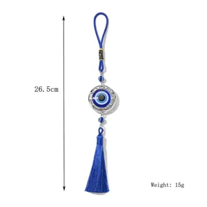 Detailansicht des blauen Evil Eye Metallanhängers mit feiner Quaste und Kordel.