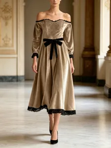 Detailed view of elegant velvet off-shoulder dress with lace trim and bow belt for events.