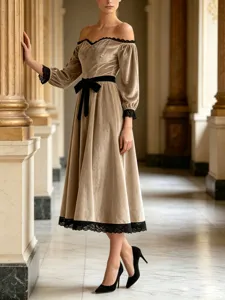 Detail view of velvet off-shoulder midi dress with black lace trim and bow for evening wear.