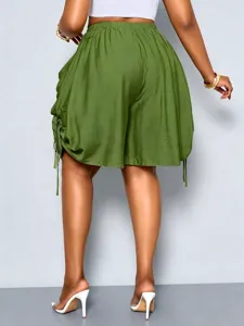 Detail view of women's high-waist drawstring harem shorts with big pockets and casual green style.