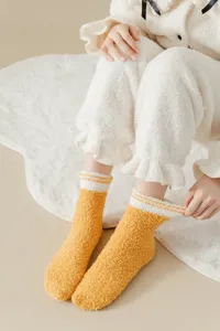 Cozy yellow coral velvet mid-tube socks with white stripes, soft warm winter home floor wear.