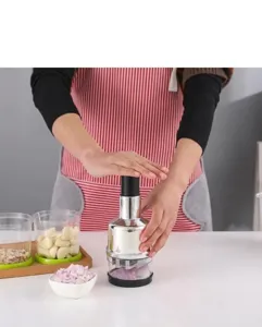 Detailed view of manual stainless steel garlic press and chopper for kitchen food prep.