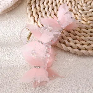 Detailed shot of a fairy pink chiffon butterfly hair claw clip with rhinestones and pearls for women.
