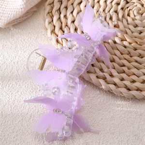 Close-up detail of the purple butterfly hair claw clip, featuring mesh wings, pearls, and rhinestones.