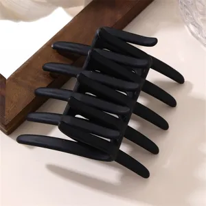 Matte black geometric hair claw clip, minimalist design, chic styling tool for autumn and winter.