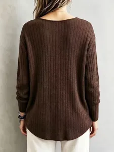 Detailed back view of a solid brown long sleeve ribbed V-neck sweater with white pants.