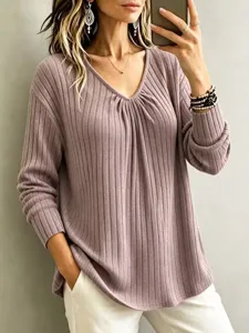 Detail view of the elegant V-neck long sleeve ribbed knit top in a soft mauve color.